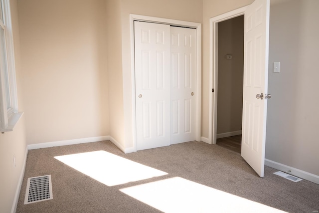 unfurnished bedroom featuring a closet and carpet floors