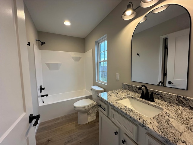 full bathroom with hardwood / wood-style flooring, vanity,  shower combination, and toilet