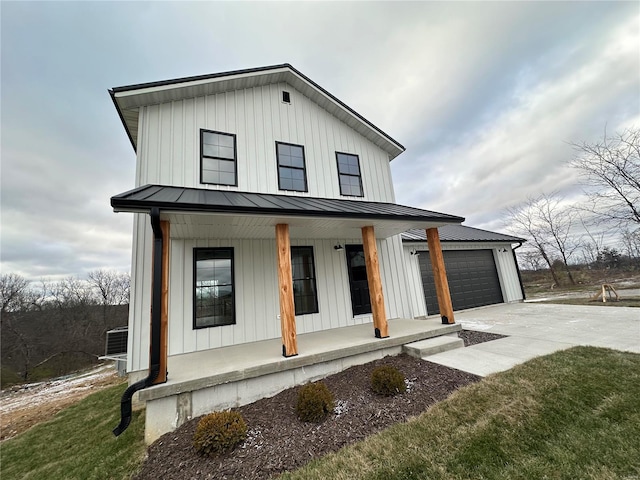 modern inspired farmhouse featuring a porch, a garage, and a front lawn