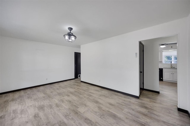 empty room with light wood-type flooring and sink