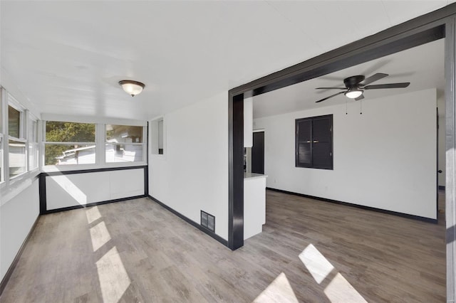 unfurnished sunroom with ceiling fan