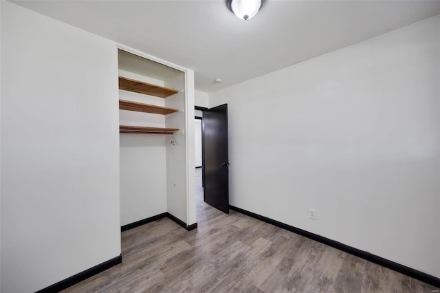 unfurnished bedroom with light wood-type flooring and a closet