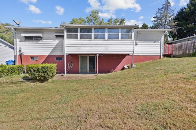 rear view of property with a sunroom and a lawn