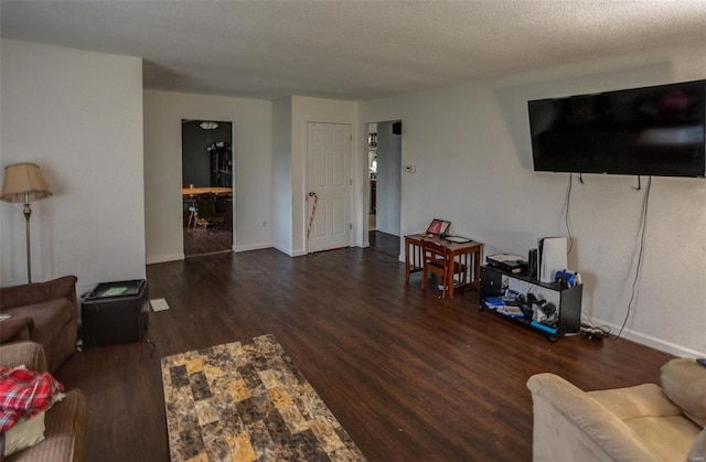 living room featuring a textured ceiling and dark wood-type flooring