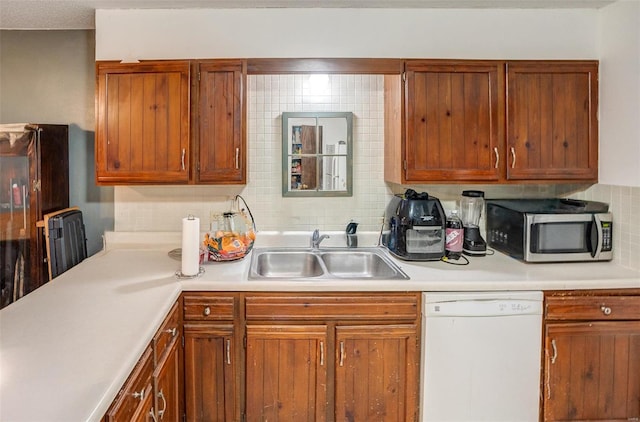 kitchen with dishwasher, decorative backsplash, and sink