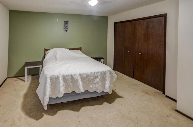 bedroom with light colored carpet, a closet, and ceiling fan