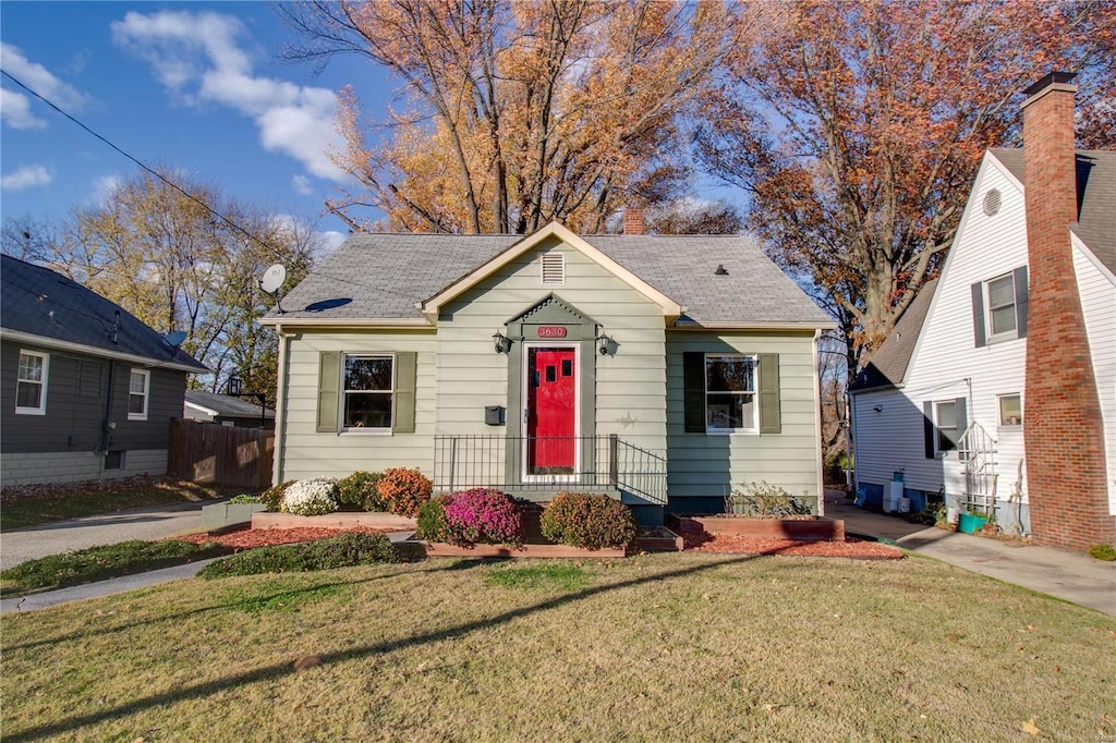 bungalow-style home featuring a front lawn