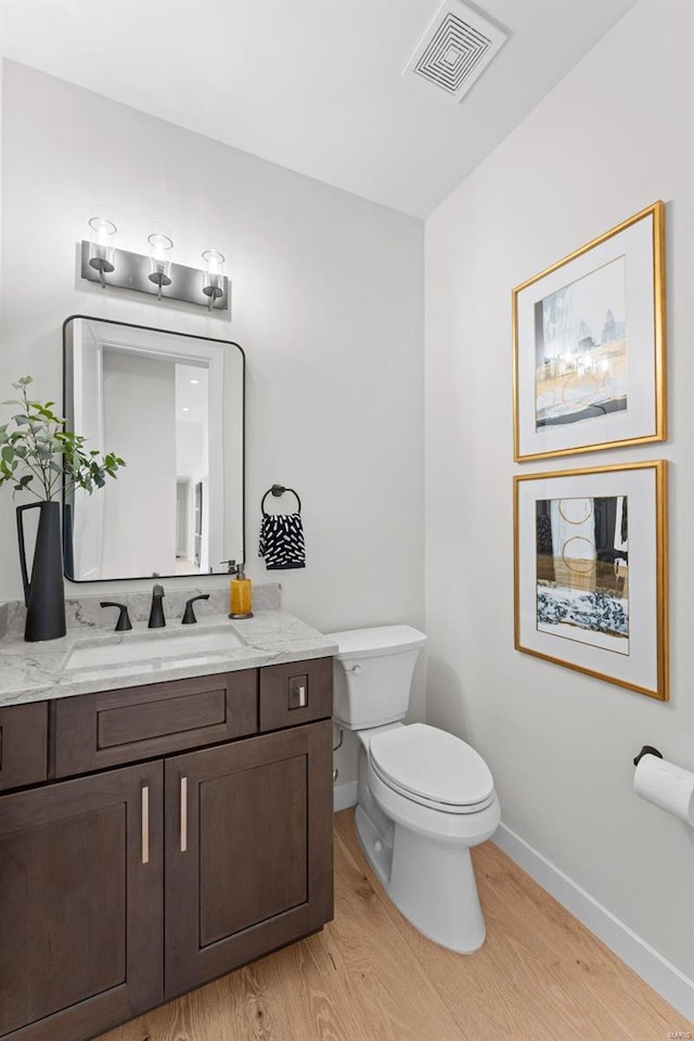 bathroom with vanity, wood-type flooring, and toilet