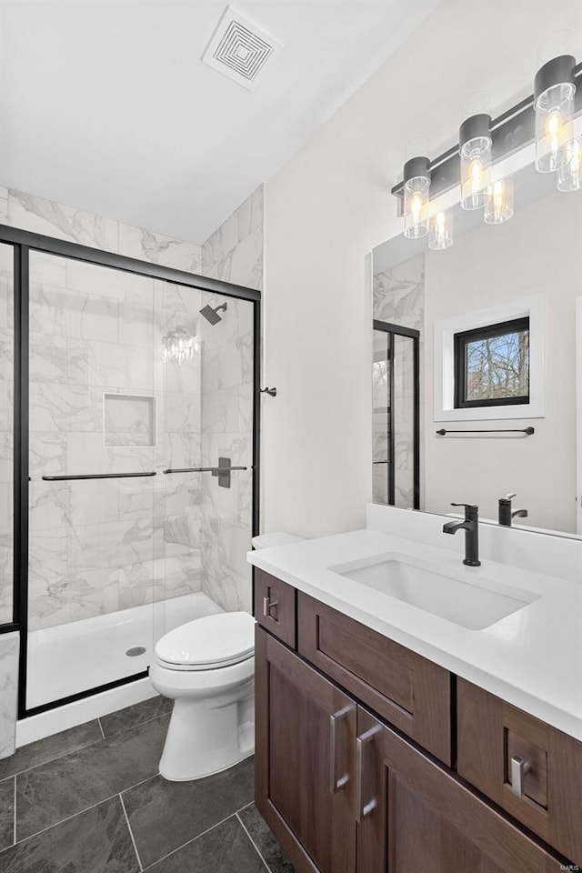 bathroom featuring tile patterned floors, vanity, toilet, and a shower with door