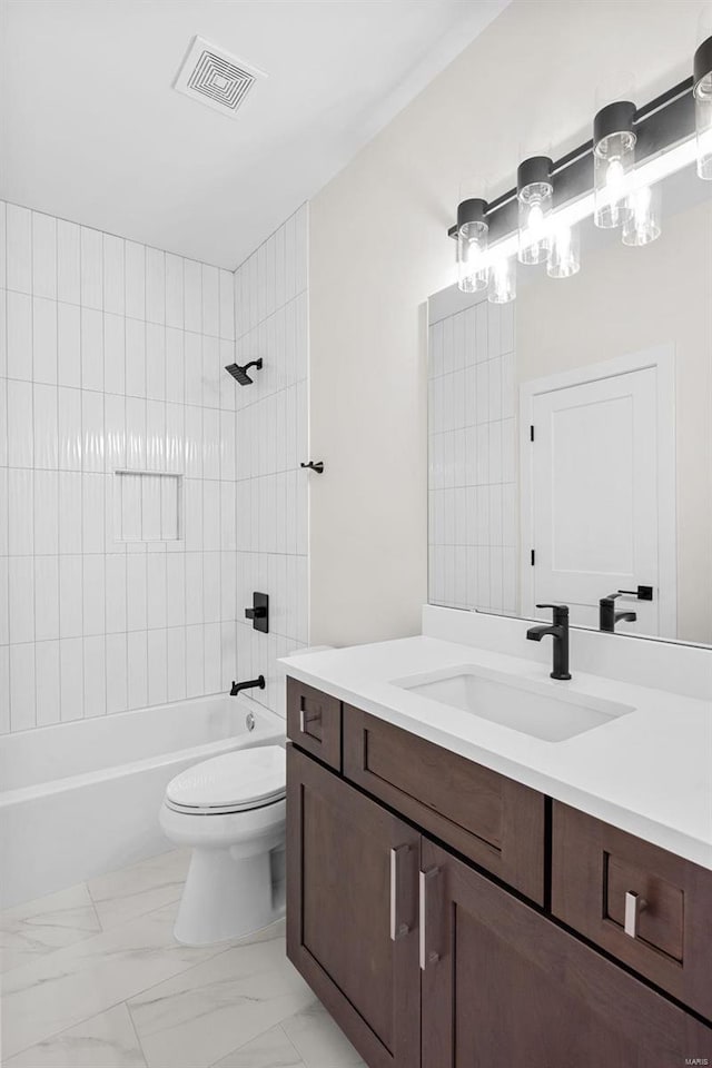 full bathroom with tiled shower / bath, vanity, and toilet