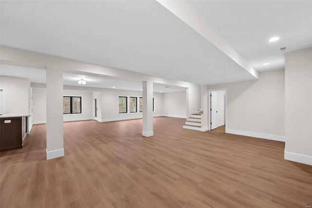 basement with light hardwood / wood-style flooring