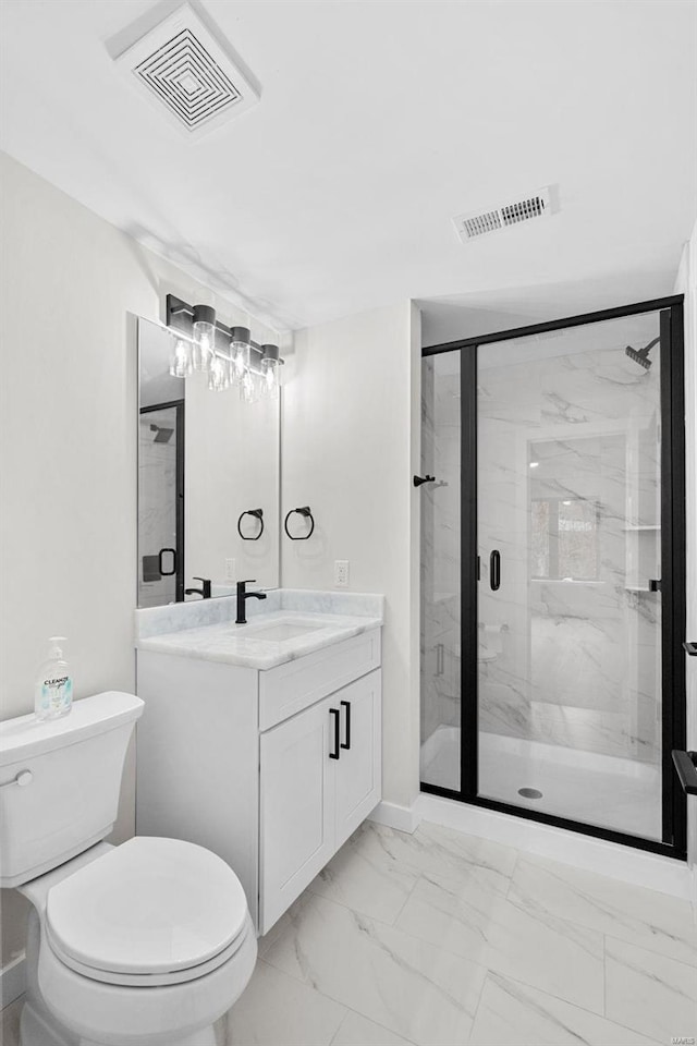 bathroom featuring vanity, toilet, and a shower with shower door