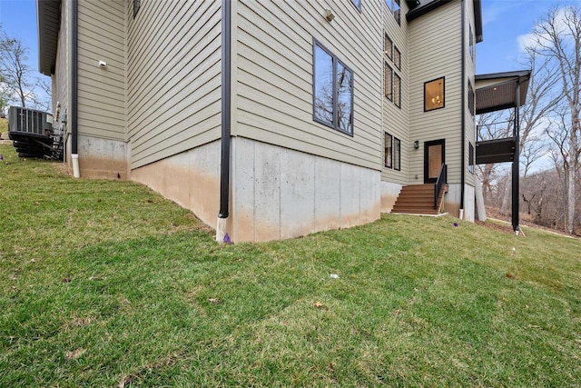 view of side of home with cooling unit and a lawn