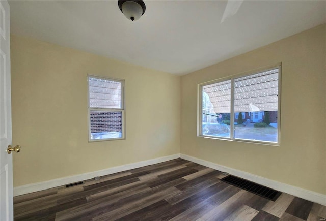 empty room with plenty of natural light and dark wood-type flooring