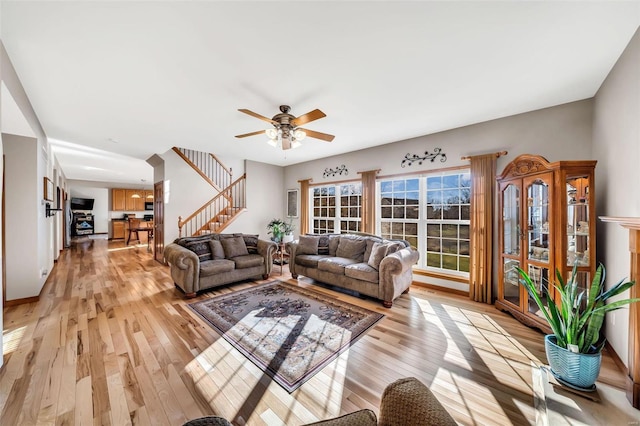 living room with ceiling fan and light hardwood / wood-style flooring