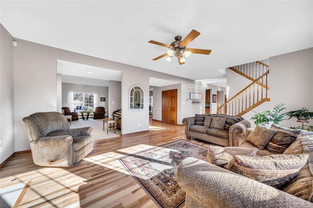 living room with ceiling fan and light wood-type flooring