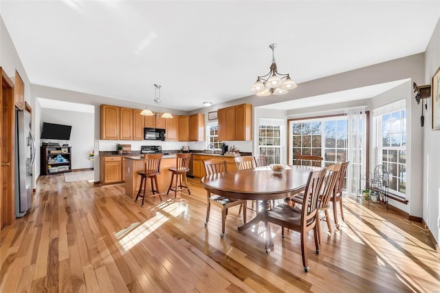 dining space featuring light hardwood / wood-style flooring, a chandelier, and sink