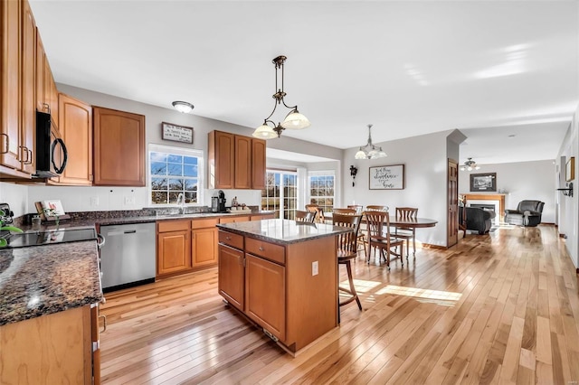 kitchen with a center island, hanging light fixtures, light hardwood / wood-style flooring, stainless steel dishwasher, and a notable chandelier