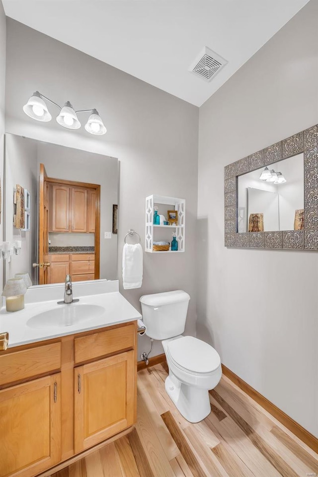 bathroom featuring hardwood / wood-style floors, vanity, and toilet