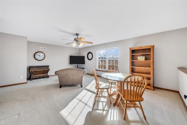 carpeted dining room featuring ceiling fan