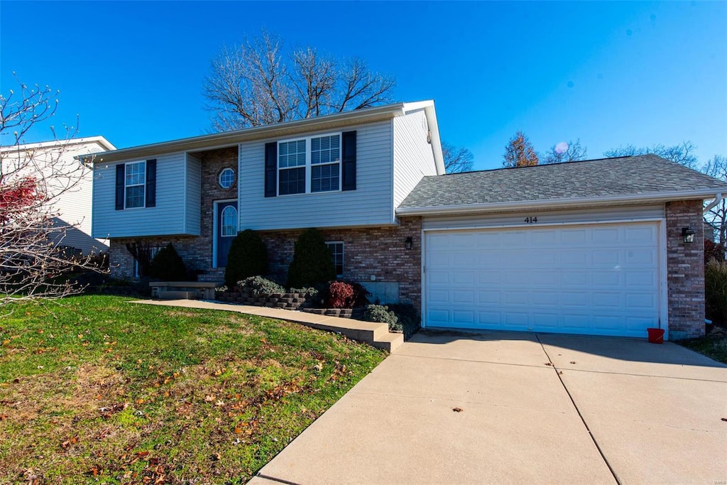 bi-level home featuring a front lawn and a garage