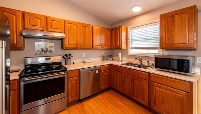 kitchen featuring light hardwood / wood-style floors, sink, lofted ceiling, and stainless steel appliances