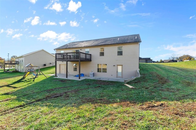 rear view of house featuring a wooden deck, a patio area, and a lawn