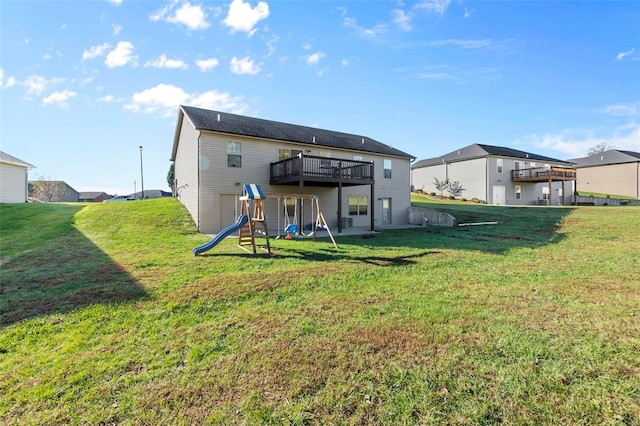 back of property featuring a playground, a wooden deck, and a lawn