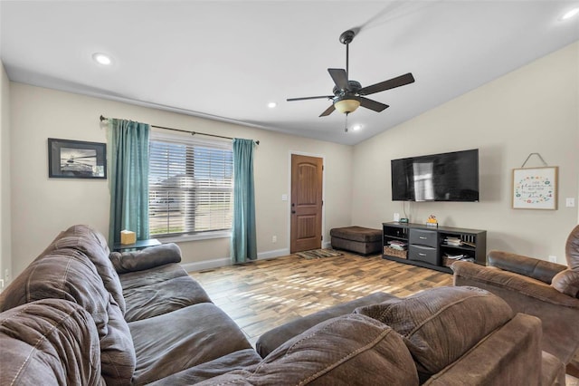 living room featuring ceiling fan, light hardwood / wood-style floors, and vaulted ceiling