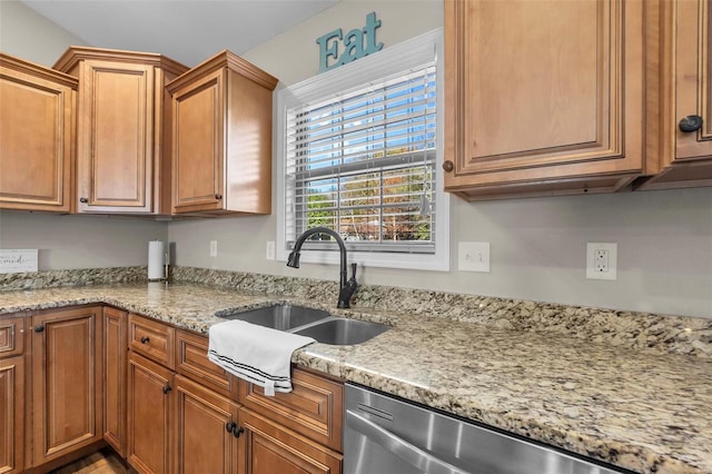 kitchen featuring dishwasher, light stone countertops, and sink