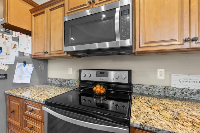 kitchen featuring light stone counters and appliances with stainless steel finishes