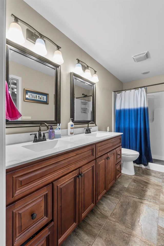 bathroom featuring vanity, toilet, and curtained shower