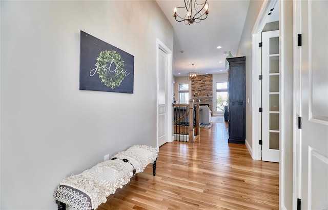 corridor featuring wood-type flooring and an inviting chandelier