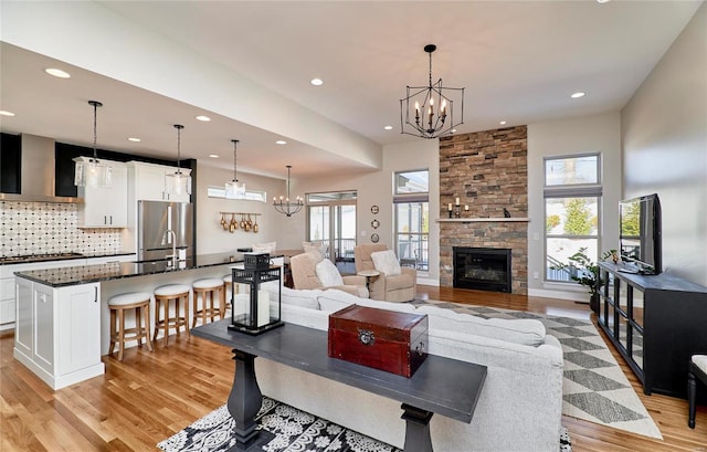 living room featuring sink, a fireplace, a healthy amount of sunlight, and light wood-type flooring