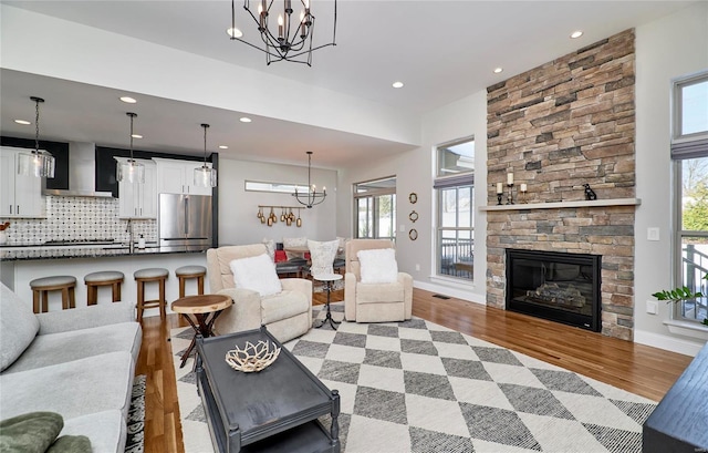 living room with light wood-type flooring and a stone fireplace