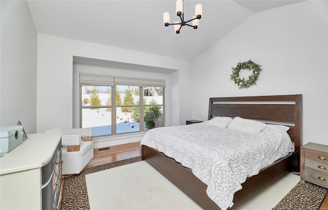 bedroom featuring dark hardwood / wood-style flooring, lofted ceiling, and a notable chandelier