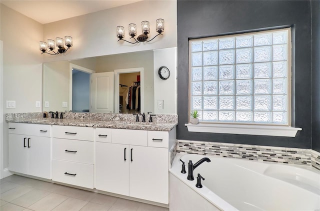 bathroom featuring tile patterned floors, vanity, and a bath