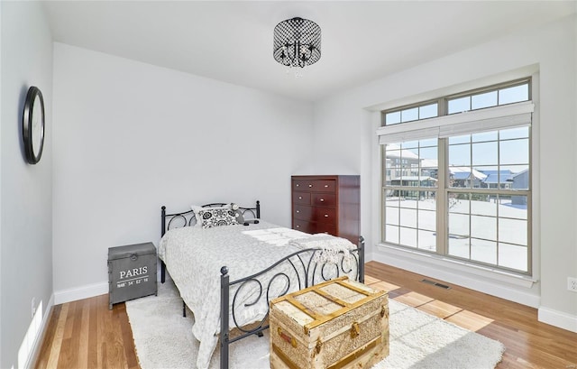 bedroom featuring wood-type flooring and an inviting chandelier