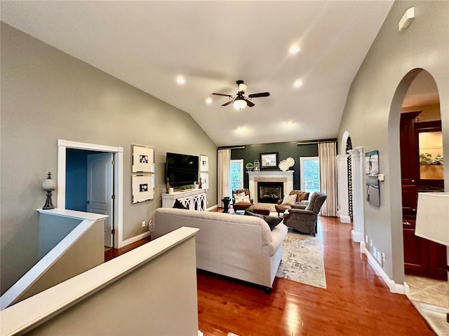 living room with ceiling fan, vaulted ceiling, and hardwood / wood-style flooring