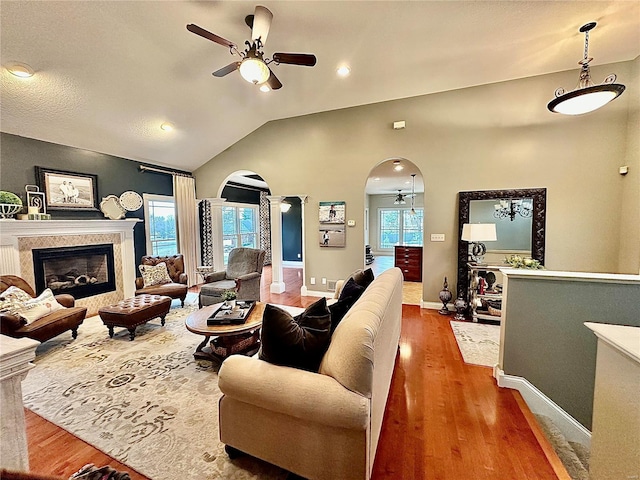 living room featuring hardwood / wood-style floors, lofted ceiling, a wealth of natural light, and a premium fireplace