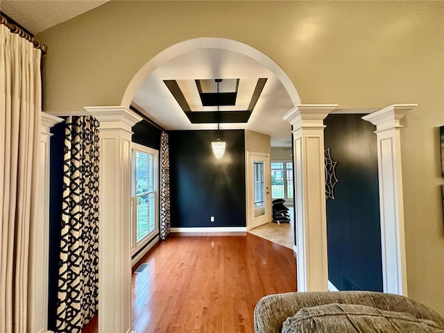 interior space with light hardwood / wood-style floors, a baseboard radiator, and decorative columns