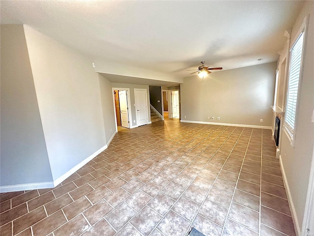 empty room with tile patterned floors and ceiling fan