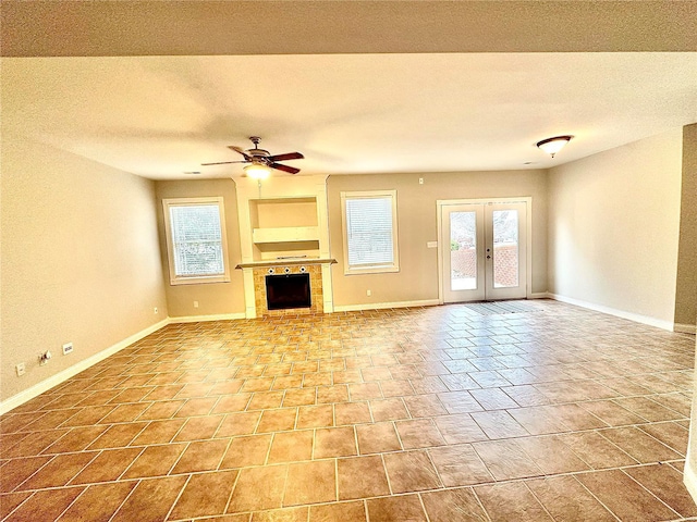 unfurnished living room featuring a fireplace, ceiling fan, french doors, and a textured ceiling