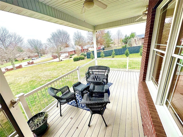 wooden deck with a yard and ceiling fan