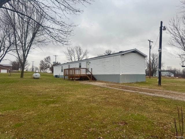 view of side of property featuring a wooden deck and a yard