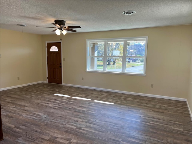 foyer entrance with a textured ceiling, dark hardwood / wood-style floors, and ceiling fan