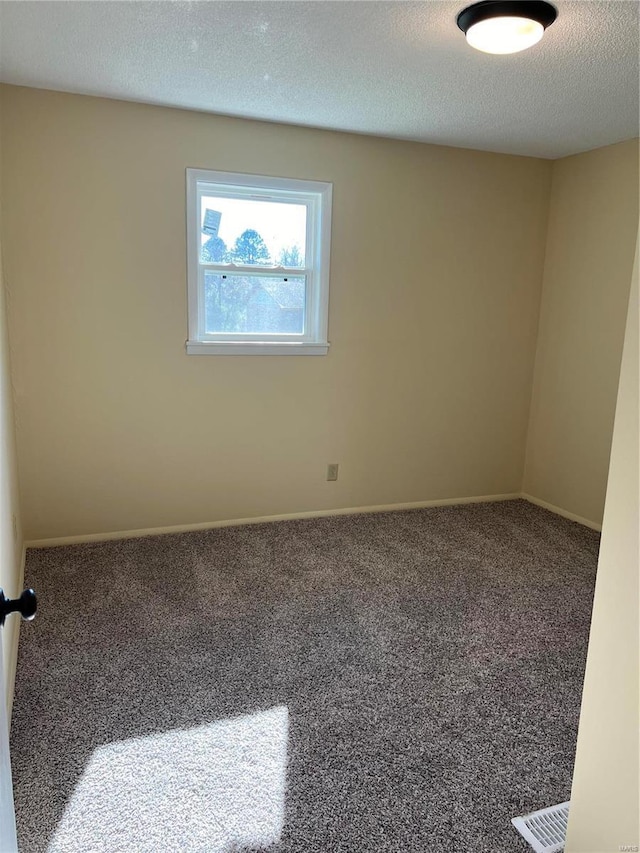 spare room featuring a textured ceiling and carpet floors