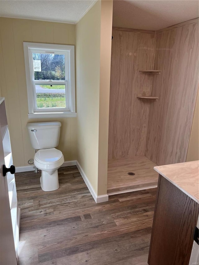 bathroom with walk in shower, vanity, a textured ceiling, hardwood / wood-style flooring, and toilet