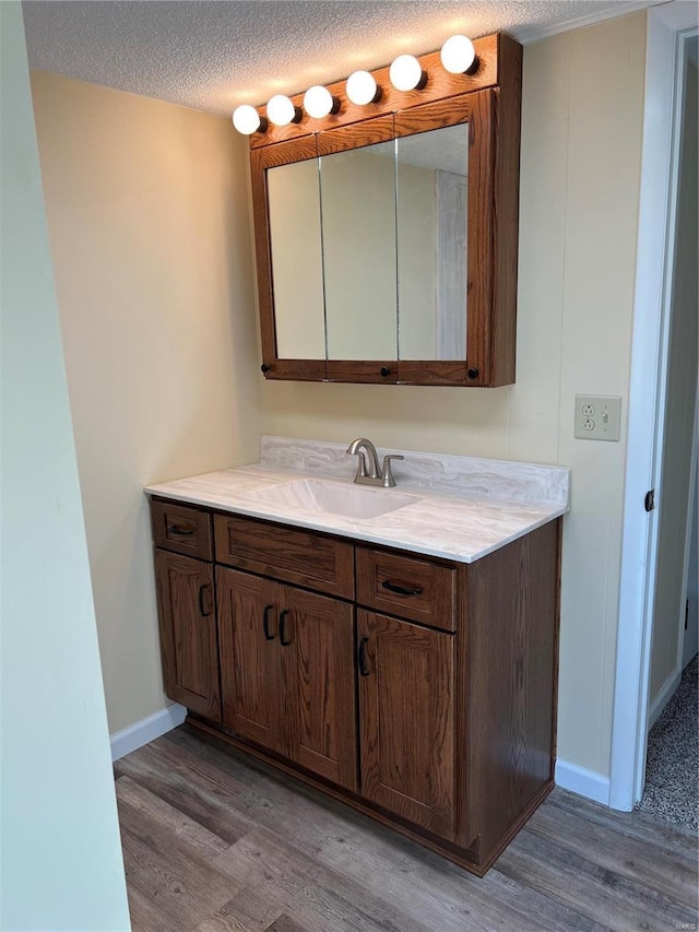 bathroom featuring vanity, wood-type flooring, and a textured ceiling