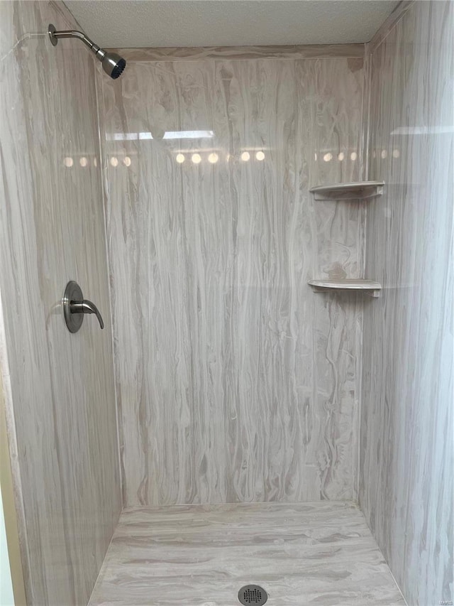 bathroom featuring tiled shower and a textured ceiling